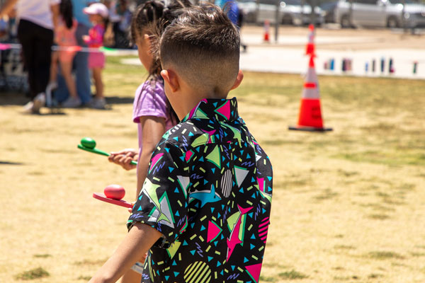 Close up of two children balancing eggs on spoons as the race.
