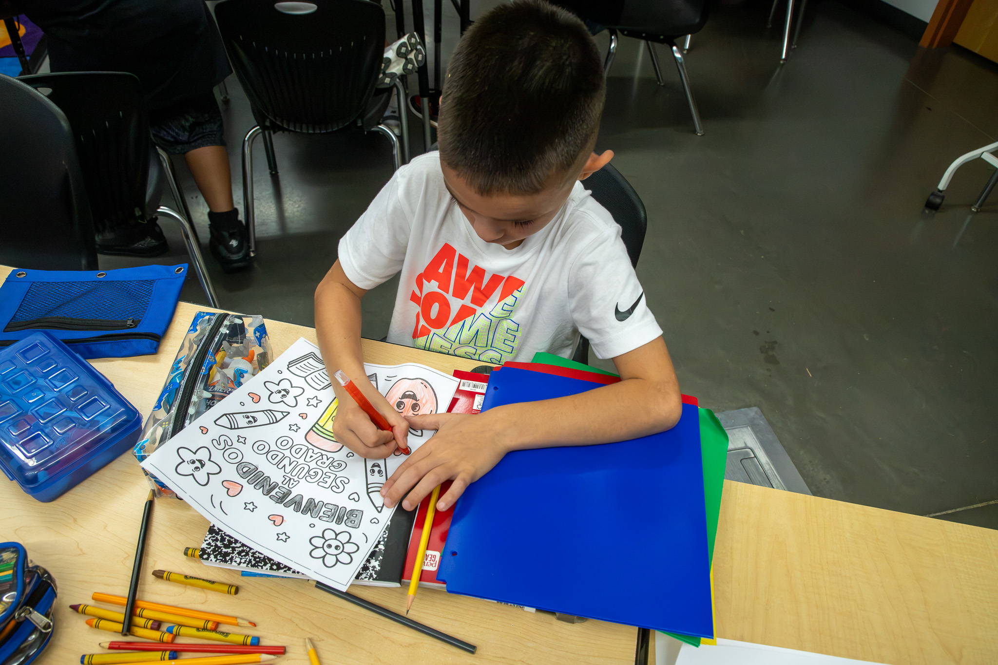 A boy colors a page in a coloring book
