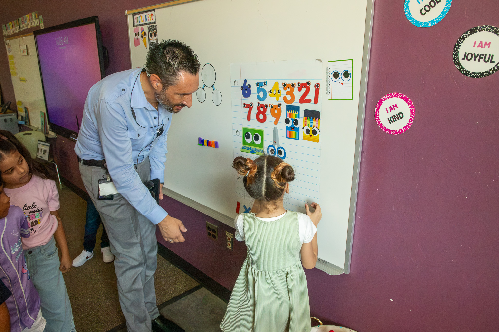McCorkle's new principal hangs out in a classroom with young students, including a young girl writing on a whiteboard